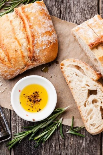 sliced bread ciabatta and extra virgin olive oil on wooden background